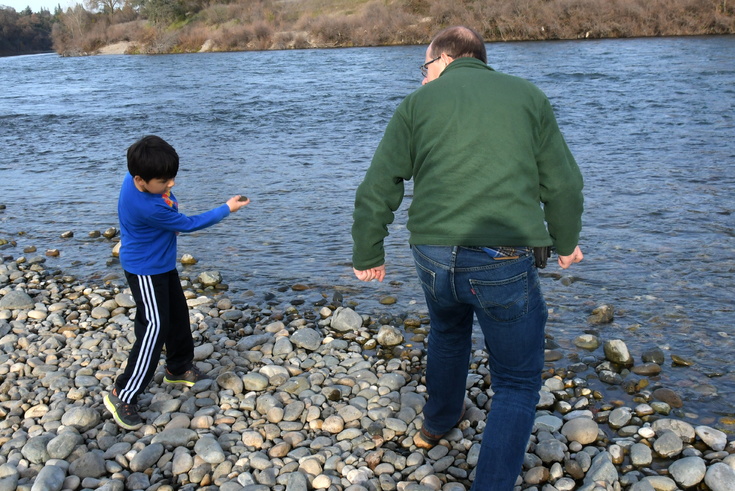 Dad instructs on stone skipping